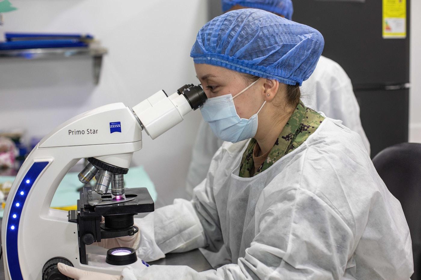A Luminex gemologist examining a stone under a lab microscope